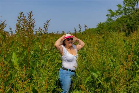 Mulher Latina americana Segurando Chapéu Na Cabeça As Mãos Para Evitar Que O Vento Sopra a