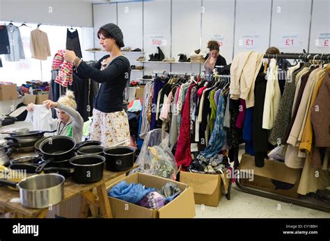 Women Browsing Racks Of Second Hand Clothes And Goods On Sale In A