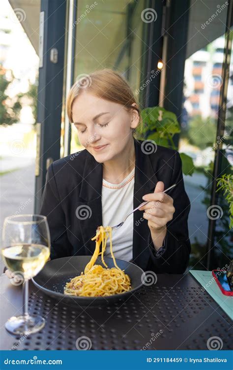 Portrait Of A Smiling Blonde Woman Eating Italian Pasta Carbonara And