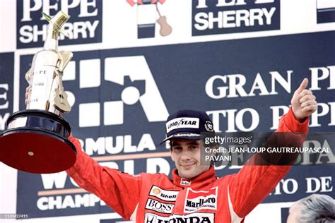 Brazilian Formula One Pilot Ayrton Senna Holds Trophy While Giving A