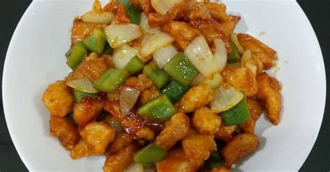 A White Plate Topped With Chicken And Veggies On Top Of A Black Table