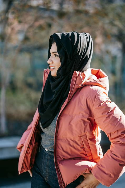 Young Muslim women laughing while resting on grass · Free Stock Photo