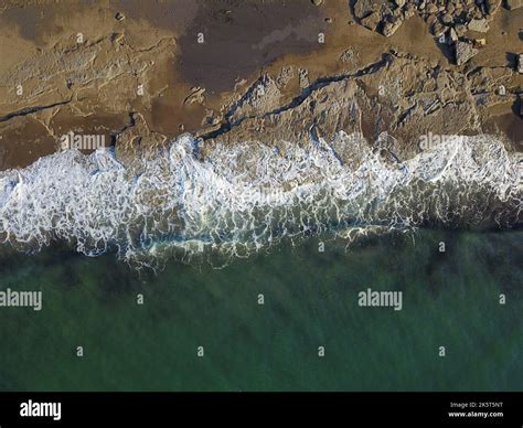 Aerial Photograph Of A Rocky Coastline With Arriving And Breaking Ocean