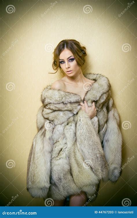 Attractive Young Woman Wearing A Fur Coat Posing Provocatively Indoor