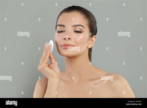 Young Woman Caring About Her Beautiful Healthy Face With Cotton Swab