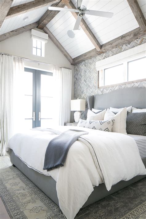 A Large Bed Sitting Under A Ceiling Fan In A Bedroom Next To A Window