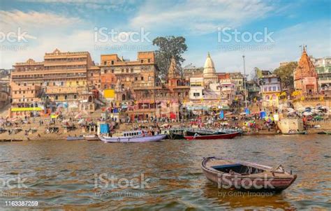 Varanasi Ancient City Architecture With Wooden Boat By The Ganges River