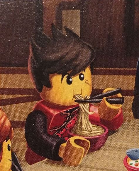 The Lego Man Is Eating Noodles With Chopsticks In His Hand And Looking