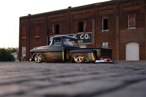 An Old Black Truck Parked In Front Of A Building