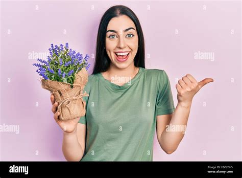 Beautiful Woman With Blue Eyes Holding Lavender Plant Pointing Thumb Up