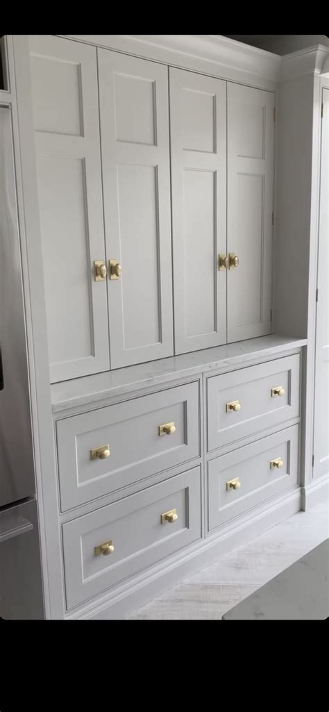 The Cabinets Are All White And Have Gold Handles