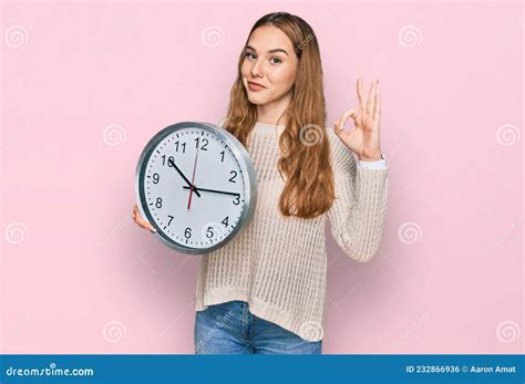 Jeune Femme Blonde Tenant Grande Horloge Faire Ok Signe Avec Les Doigts Sourire Amical Gestation
