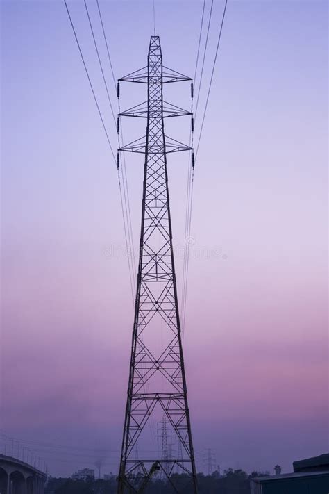 High Voltage Electricity Pylon Under The Cloudy Blue Sky Stock Photo