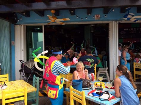 A Group Of People Sitting At Tables In Front Of A Store