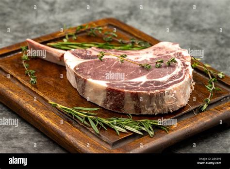 Raw Veal Chop On Dark Background Raw Veal Chop On Wooden Serving Board