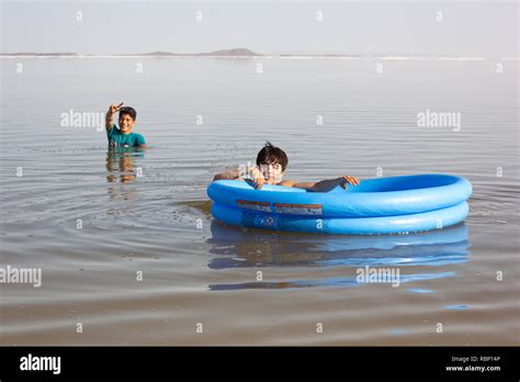 The Children Are Swimming With Their Plastic Boat In The Salt Urmia