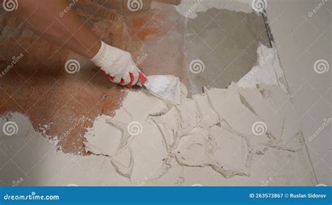 A Worker Applies Plaster To A Wall With A Spatula White Solution