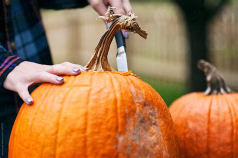 Carving Woman Uses Knife To Cut Off Top Of Pumpkin Del Colaborador