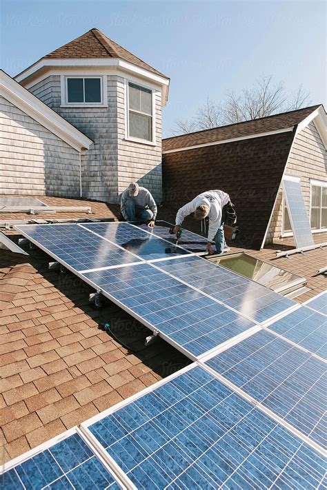 Solar Panel With Blue Collar Labor Installation On Roof Of Home By