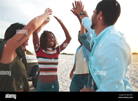 Exuberant Young Friends High Fiving On Beach Stock Photo Alamy