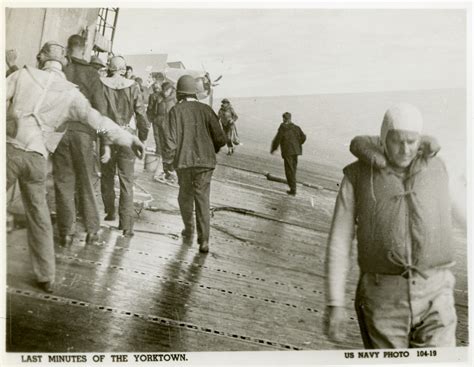 US sailors walking on the tilted deck of the USS Yorktown off the coast ...