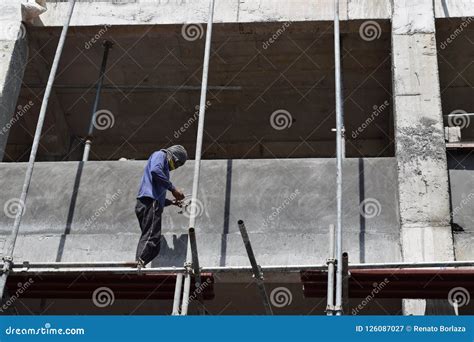 Filipino Construction Workers Installing Metal Pipe Scaffolds On High