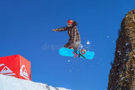 Um Voo Masculino Do Cavaleiro Do Snowboard De Um Salto De Esqui No