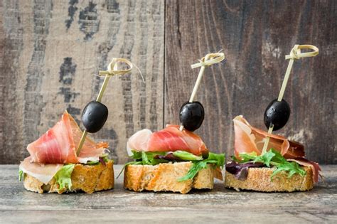 Premium Photo Spanish Serrano Ham Skewer With Olive And Lettuce On