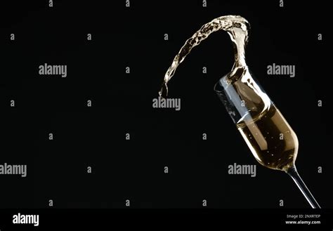 Sparkling Wine Splashing Out Of Glass On Black Background Stock Photo