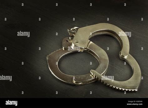 Metal Police Handcuffs On A Dark Wooden Board Silver Handcuffs