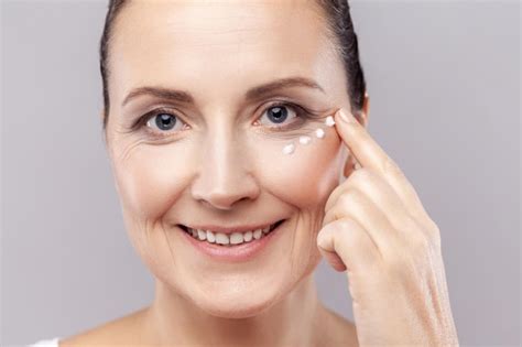 Mujer De Mediana Edad Aplica Crema Facial Se Preocupa Por La Tez Toca