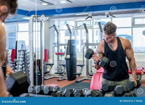 Homem Que Exercita Pesos Na Frente Do Espelho Imagem De Stock