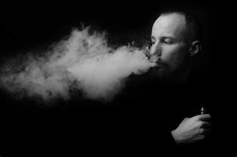 Premium Photo Man Smoking Electronic Cigarette Against Black Background