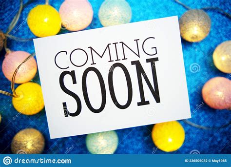 Coming Soon Text On Paper Card With Led Cotton Balls Decoration On Blue