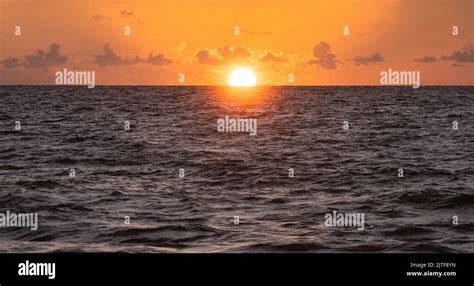 Sun Rising Over Ocean Stock Photo Alamy