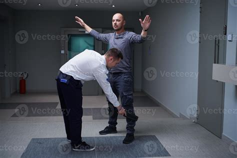 Security Guard With A Metal Detector Making Body Searching Procedure On