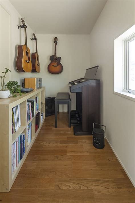 A Living Room With Guitars On The Wall And Bookshelves In Front Of It