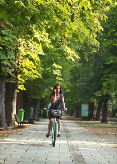 Premium Photo Portrait Of Smiling Mid Adult Woman Riding Bicycle On Road