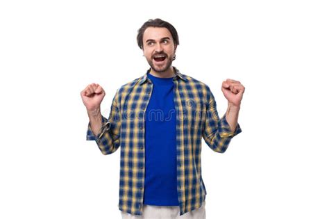 Happy Brunette Brutal Man With A Beard In A Plaid Shirt Rejoices In