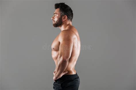 Side View Portrait Of A Concentrated Strong Shirtless Male Bodybuilder