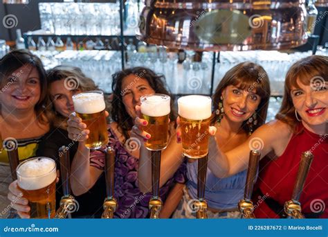 Un Grupo De Mujeres Maduras Está Bebiendo Cerveza Frente A Un Barril De