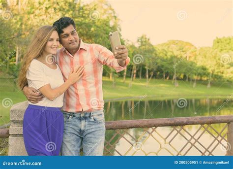 Happy Multi Ethnic Couple Smiling And In Love While Taking Selfie