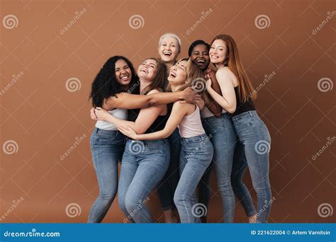 Six Multiracial Females In Casuals Hugging Together On Brown Background