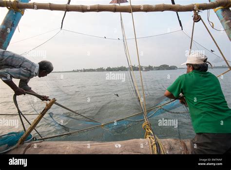 Fishermen Working A Chinese Fishing Net In Fort Kochi Kerala India