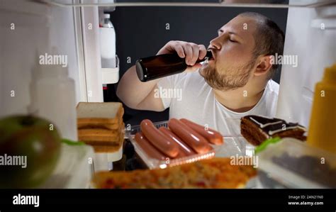 Fat Man Drinking Beer With Pleasure From Fridge At Night Unhealthy