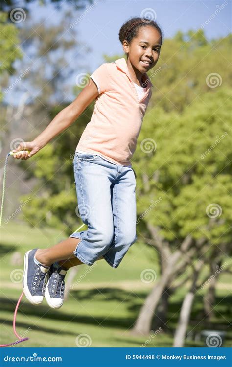 Young Girl Using Skipping Rope Outdoors Smiling Royalty Free Stock