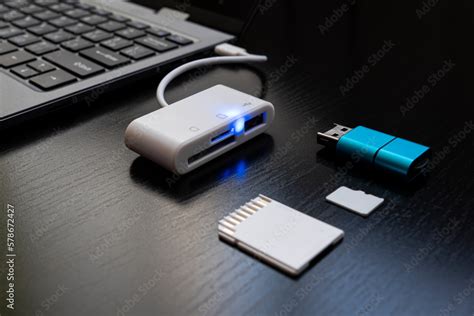 Laptop with USB Type-C adapter with pluged USB cables and SD card. The ...