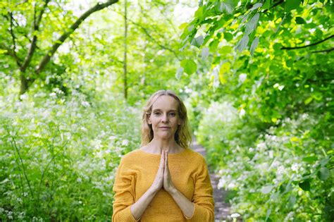 Confident Mature Woman With Hands Clasped By Trees Stock Photo