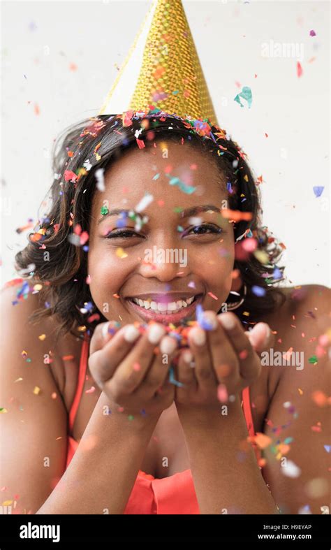 Mixed Race Woman Wearing Party Hat Blowing Confetti Stock Photo Alamy