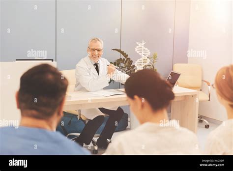 Smiling Mature Tutor Looking At His Students Stock Photo Alamy